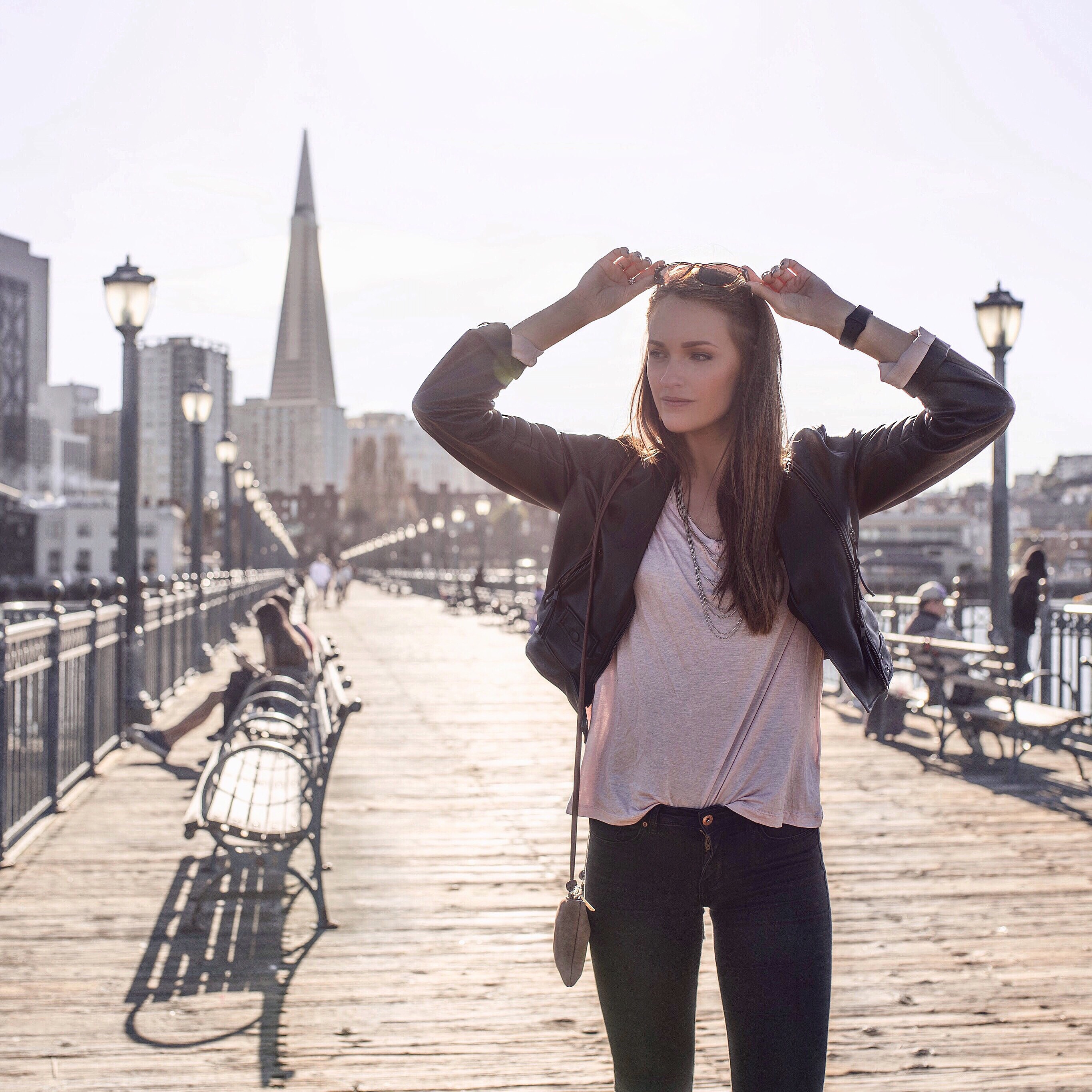Alexandra Andersson ståendes på en bro med stad i bakgrunden