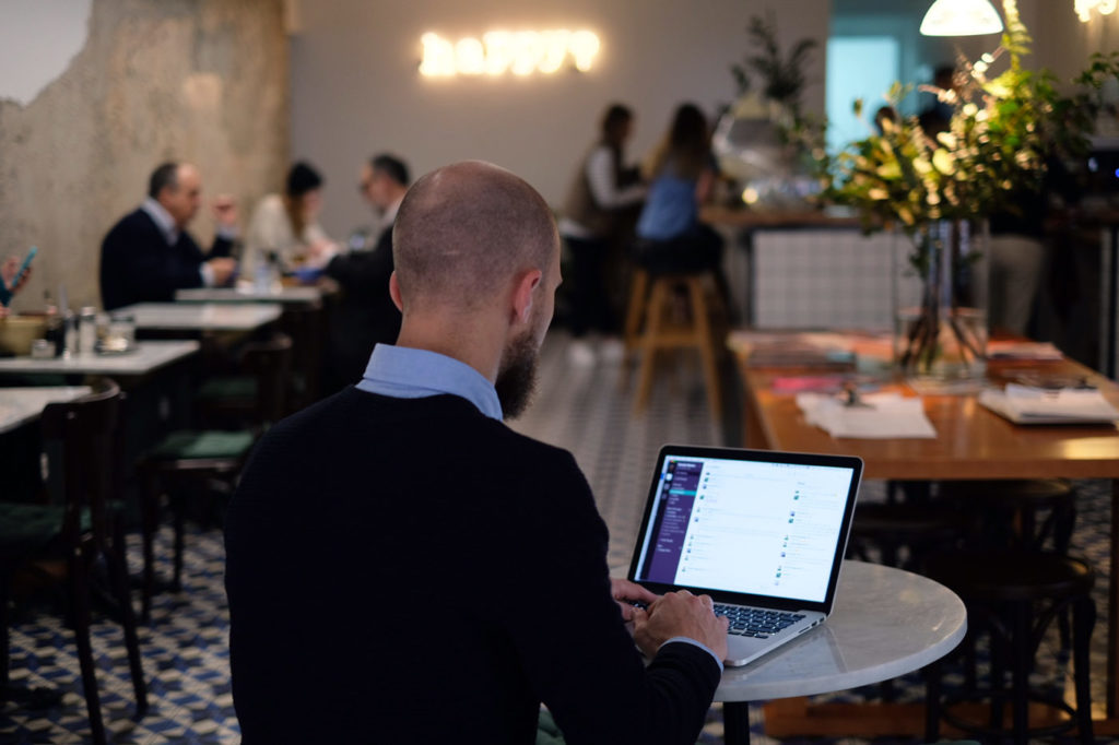 Christoffer från Svenska Nomader sitter med Slack uppe på Bowls & bar i Lissabon