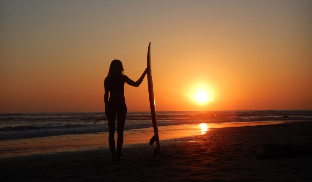 Emelie Ering med surfbräda i horisonten