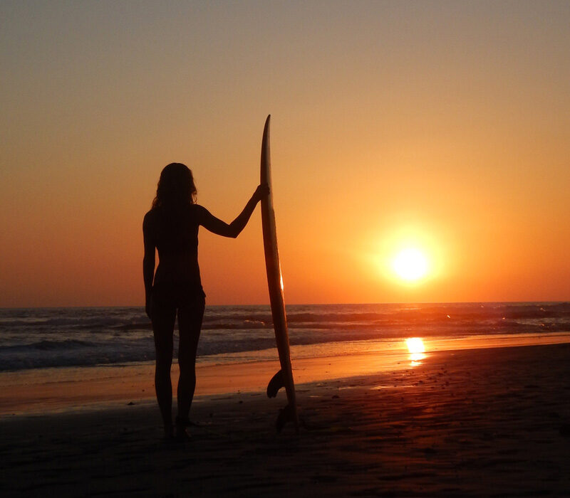 Emelie Ering med surfbräda i horisonten