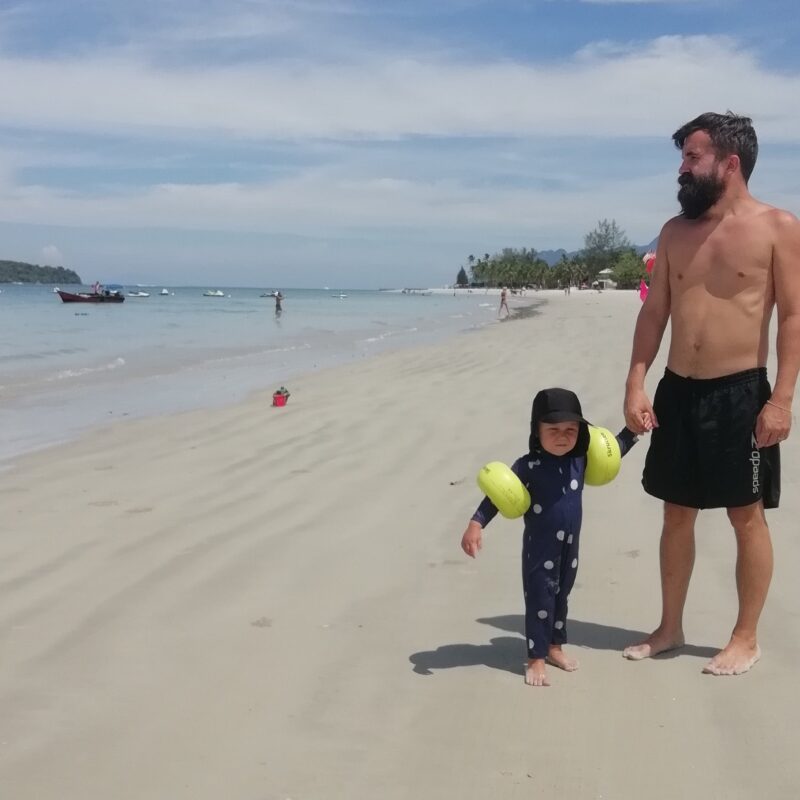 pappa på stranden med sin tvååriga son