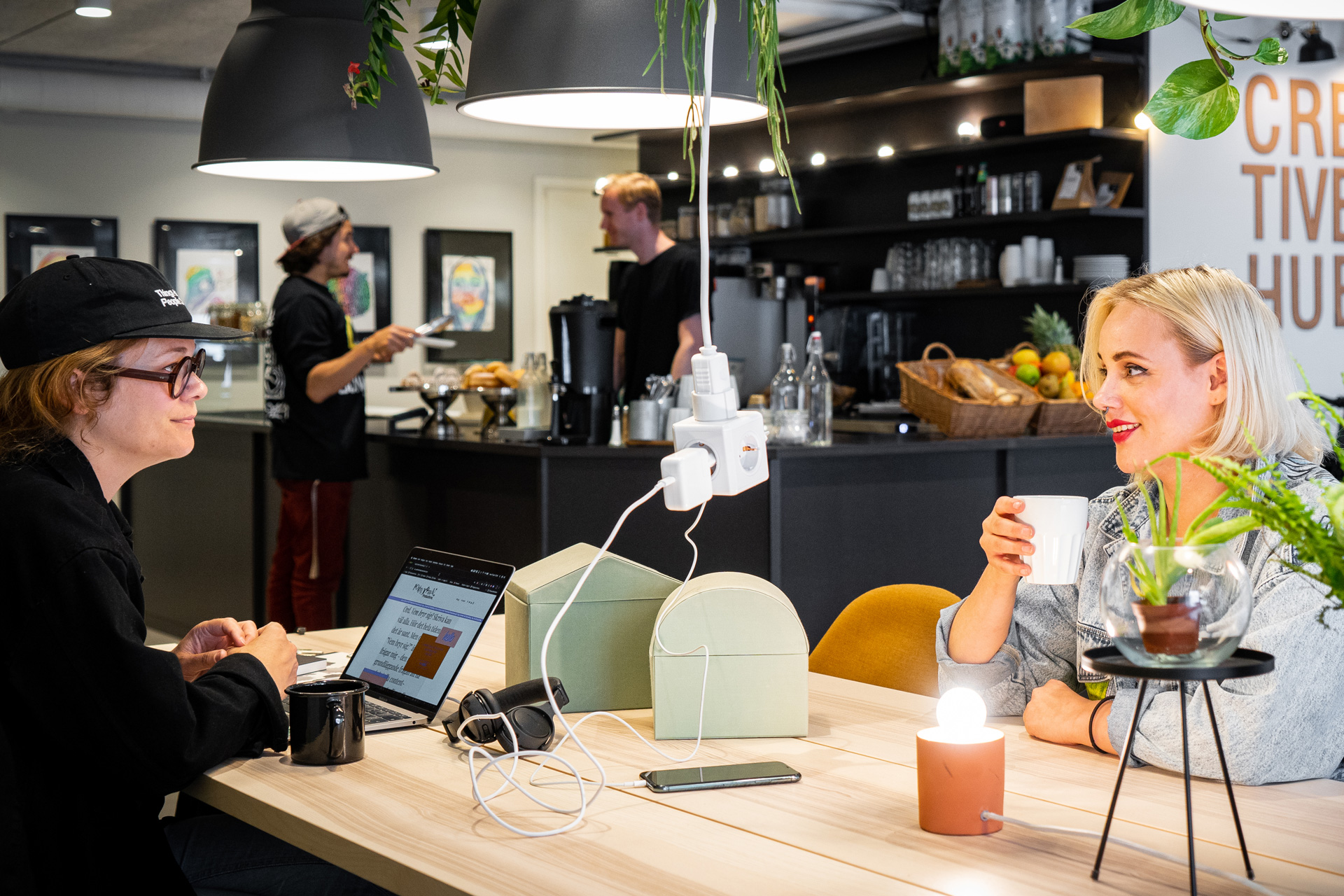 Två tjejer pratar över en kaffe på Creative Hubs Kaffe & Wifi-koncept