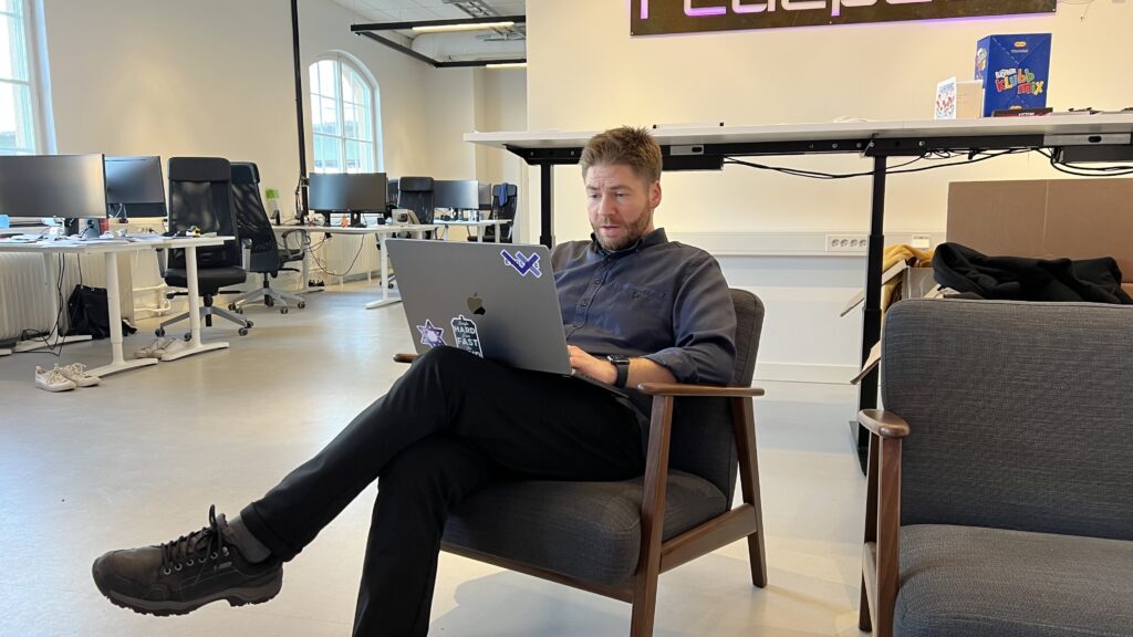 Lars Hasselrot, VD på Evolate, på en stol i mitten av deras kontorsmiljö.